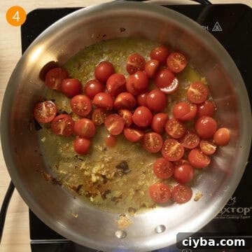 Cherry Tomatoes and white wine added to pan to simmer with garlic.