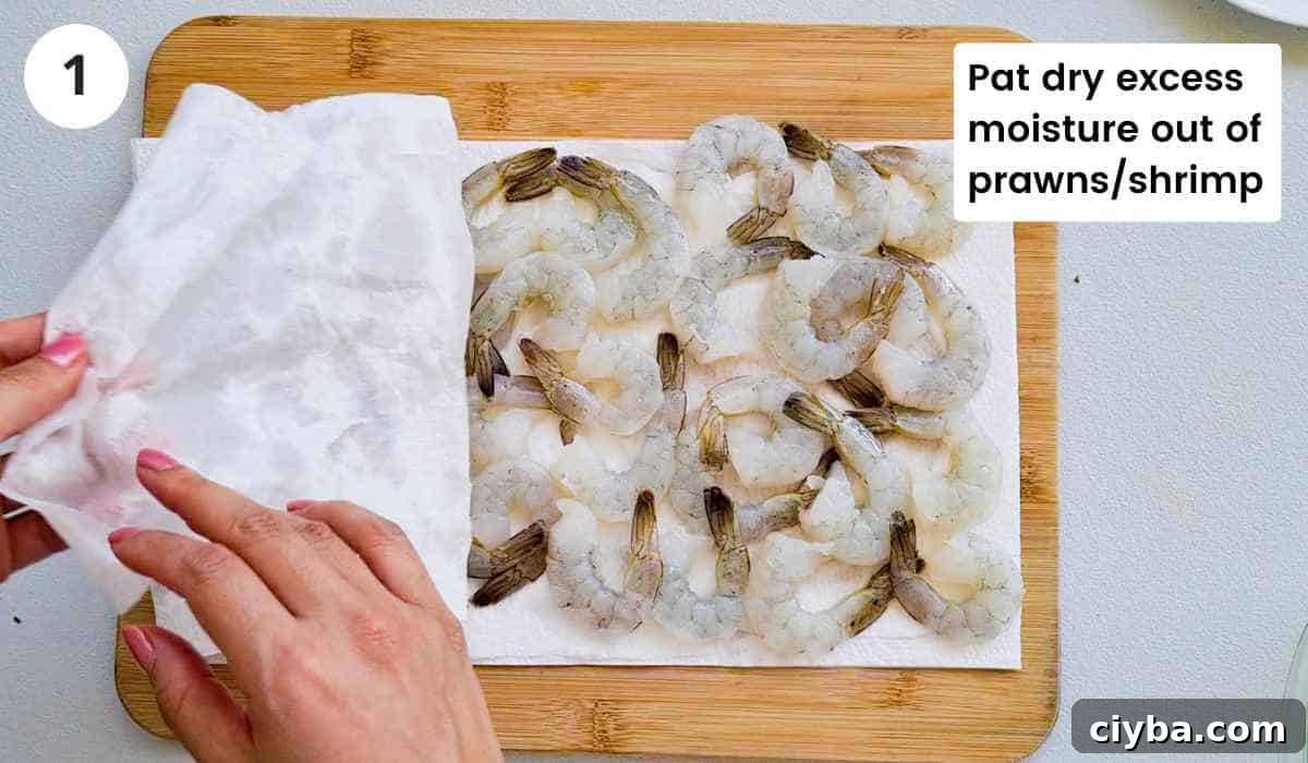 shrimp (prawns) being dabbed dry with paper towel with caption