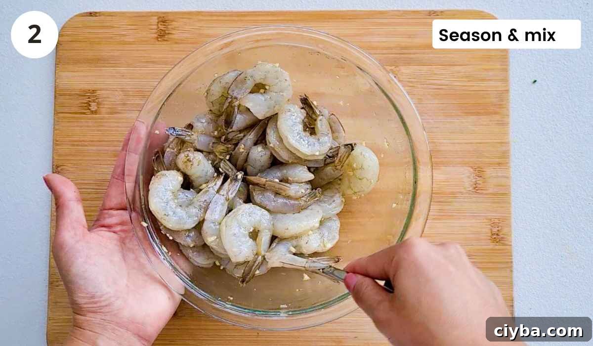 Shrimp (prawns) being mixed in seasoning with caption