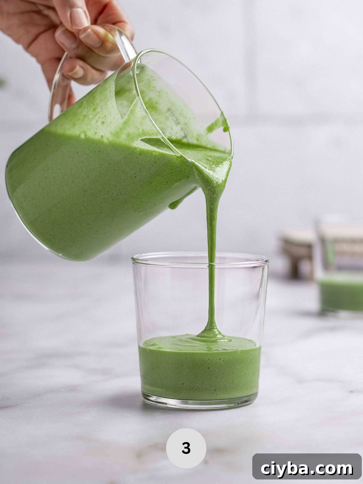 Pouring the spinach smoothie into a serving glass.