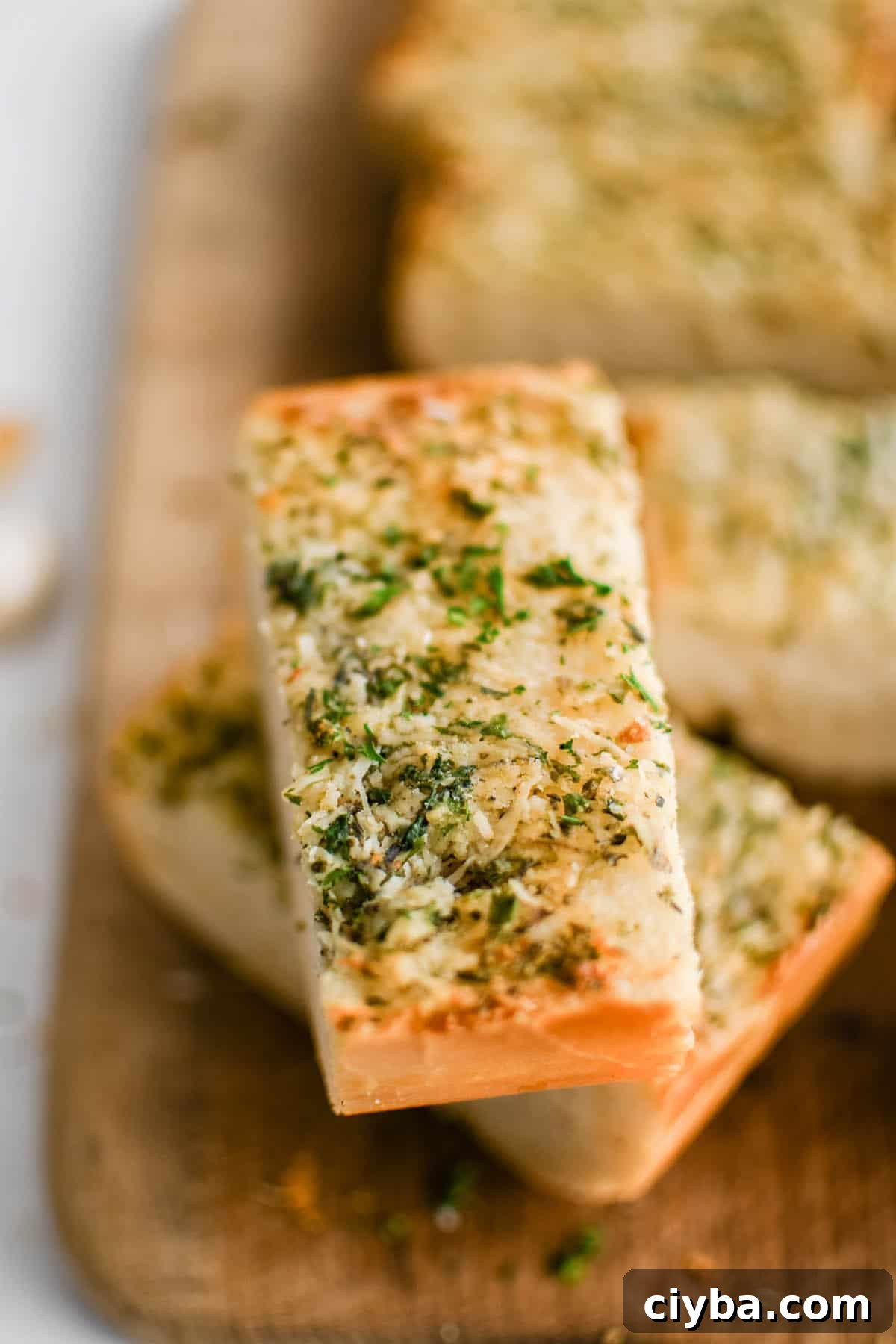 Crispy Garlic Bread Recipe with Herbed Butter 2 close up image of a piece of garlic bread