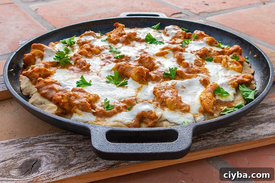 butter chicken pizza on a cast iron skillet