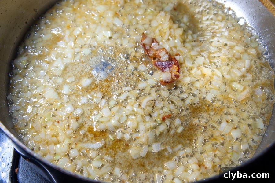 onions and cider cooking in a pan
