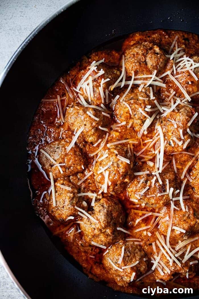 Keto Super Bowl Party Menu: Low-Carb Game Day Recipes 14 overhead view of keto meatballs with marinara sauce topped with shredded parmesan cheese in a black skillet