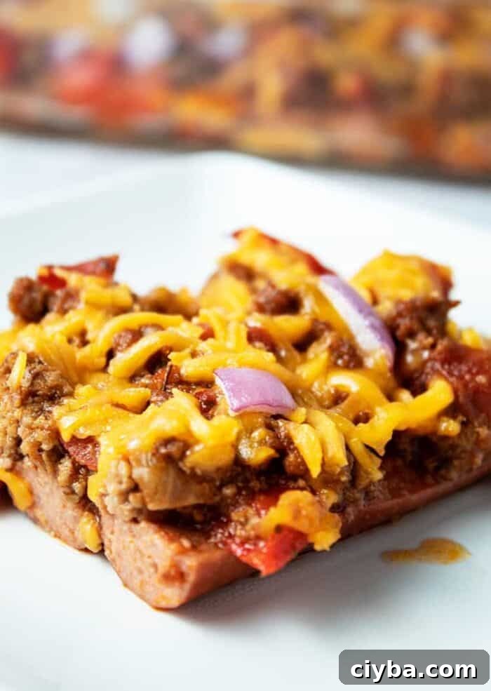 Keto Super Bowl Party Menu: Low-Carb Game Day Recipes 22 piece of keto chili dog casserole on a white plate with casserole dish in background
