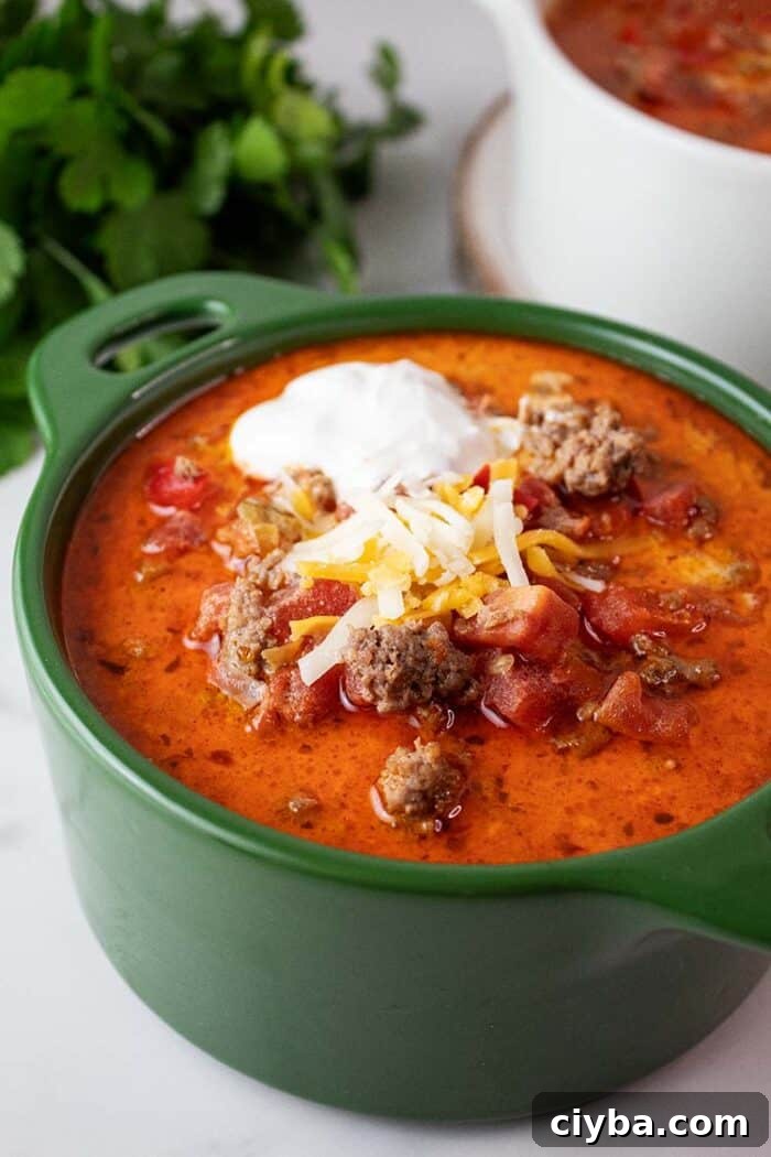 Keto Super Bowl Party Menu: Low-Carb Game Day Recipes 27 sideview of a bowl of keto taco soup topped with sour cream and Mexican shredded cheese