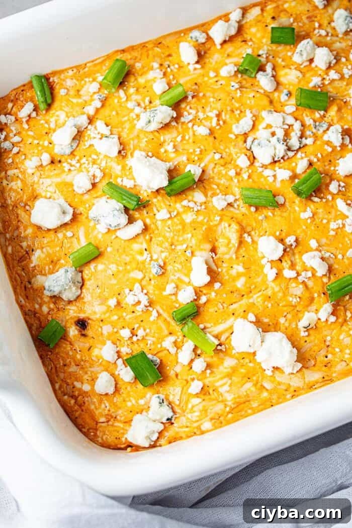 Keto Super Bowl Party Menu: Low-Carb Game Day Recipes 4 overhead view of white cassserole dish with orange colored keto buffalo chicken dip with blue cheese and chopped green onion sprinkled on top