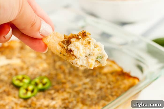 Keto Super Bowl Party Menu: Low-Carb Game Day Recipes 5 woman's hand scooping keto jalapeno popper dip in pork rind