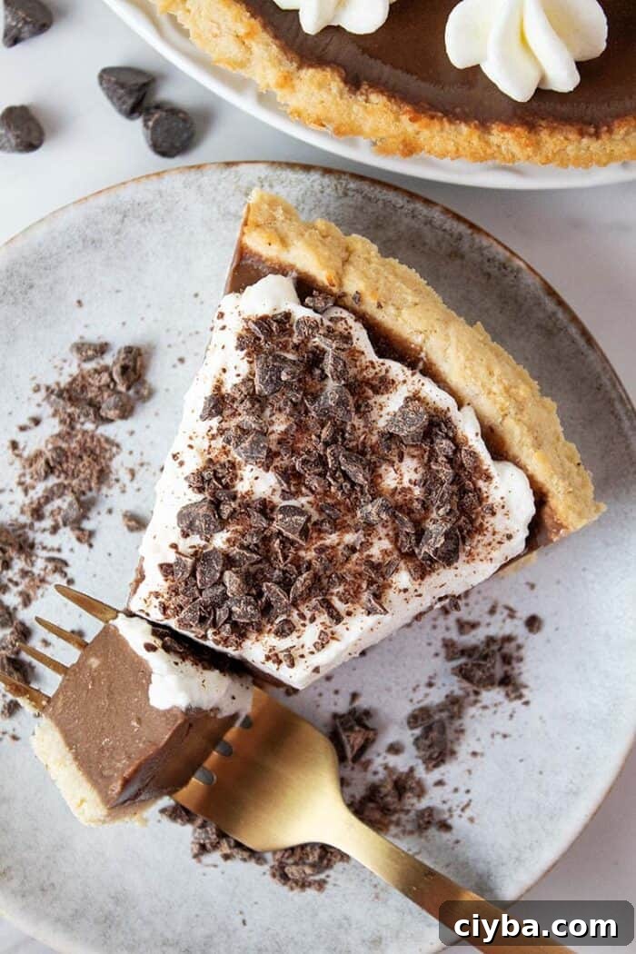 Keto Super Bowl Party Menu: Low-Carb Game Day Recipes 42 overhead view of keto chocolate pie topped with sugar free whipped cream and chocolate shavings on a swerving dish with a gold fork