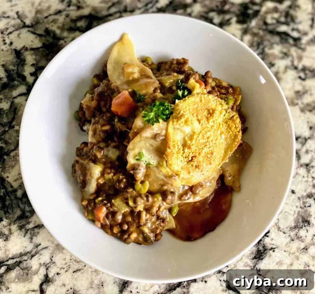 Hearty Vegan Shepherd's Pie with Lentils and Mushrooms 2 Cottage pie, also called vegan shepherd's pie recipe, is served in a bowl on the counter.