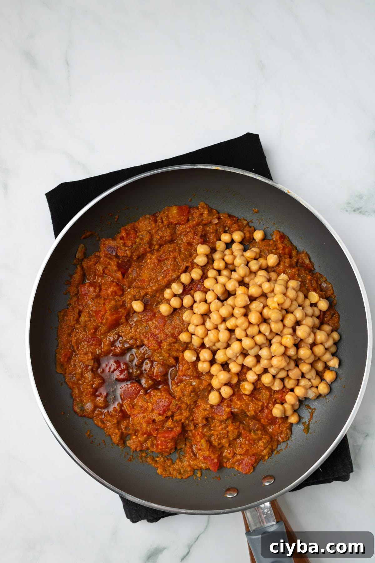 An overhead image of adding chickpeas.