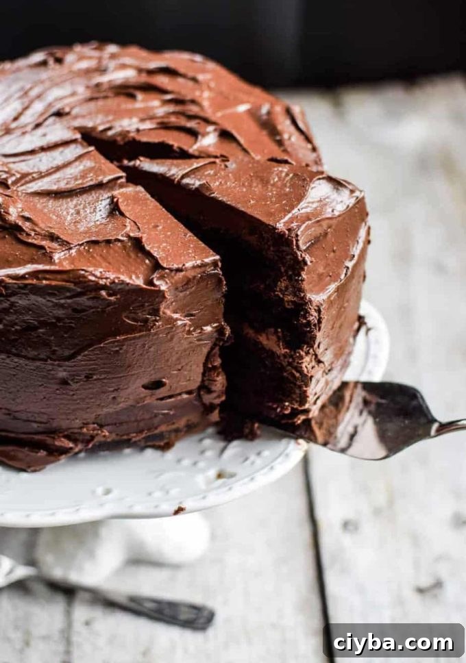 Sourdough chocolate cake sliced into pieces on a plate. A cake server is removing one slice. 