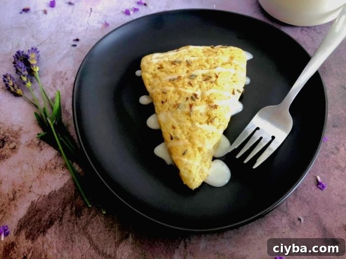 A lavender sourdough scone on a plate with a fork.