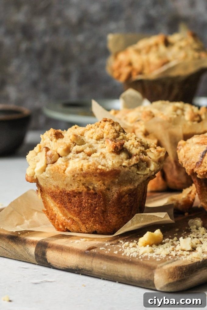 Sourdough discard banana bread muffin sitting on a cutting board and a piece of parchment.