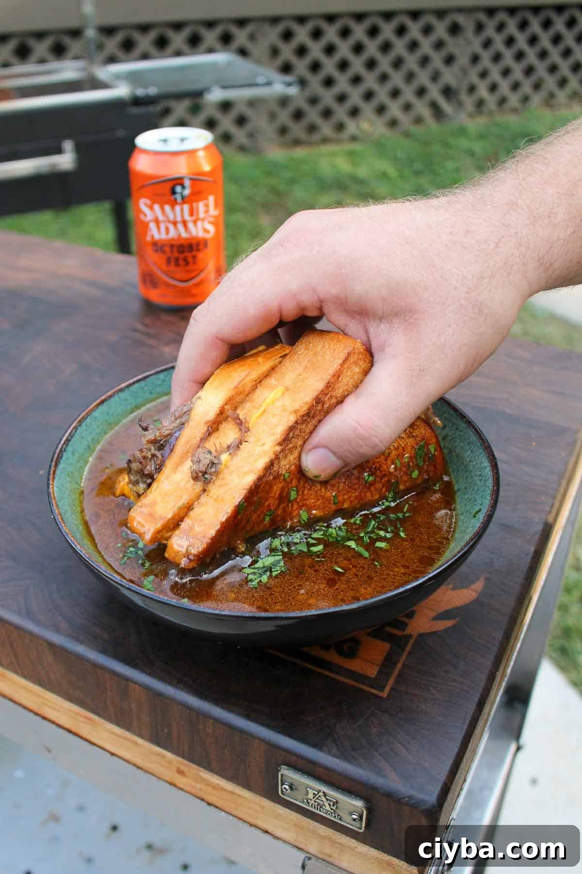 The beef patty melt is dipped in the spicy braising sauce. 