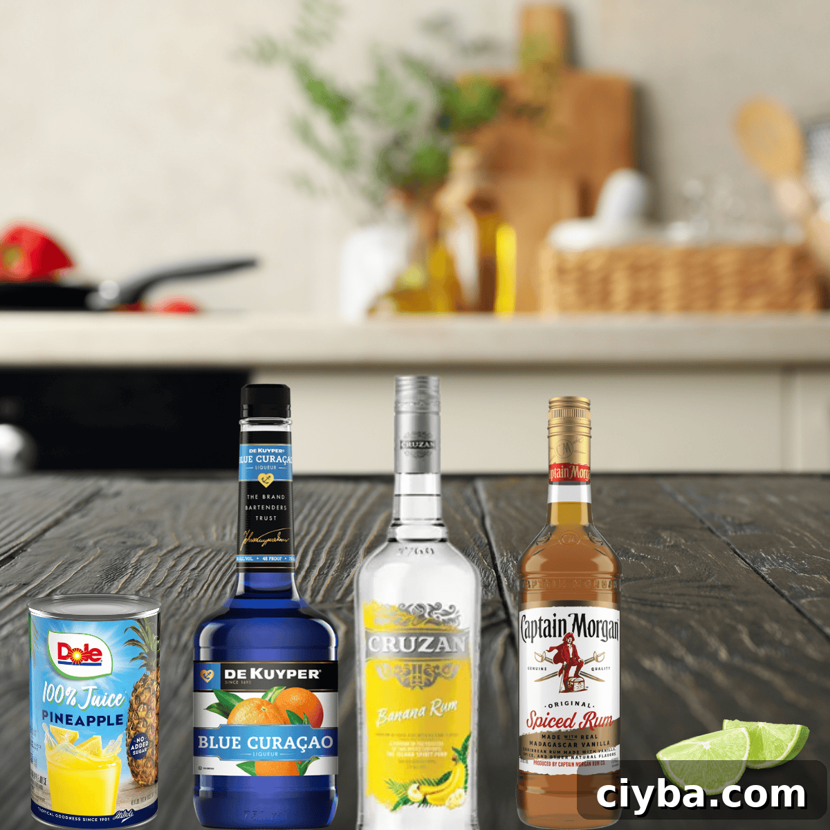Mermaid Cocktail Recipe: Tropical Blue Drink 3 spiced rum, banana rum, blue curacao, pineapple juice, and lime wedges on a dark wood counter.