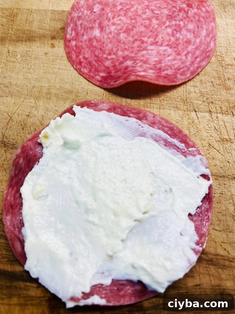 adding cream cheese to salami