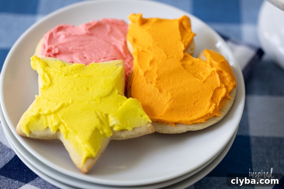 three frosted sugar cookies on a small plate.