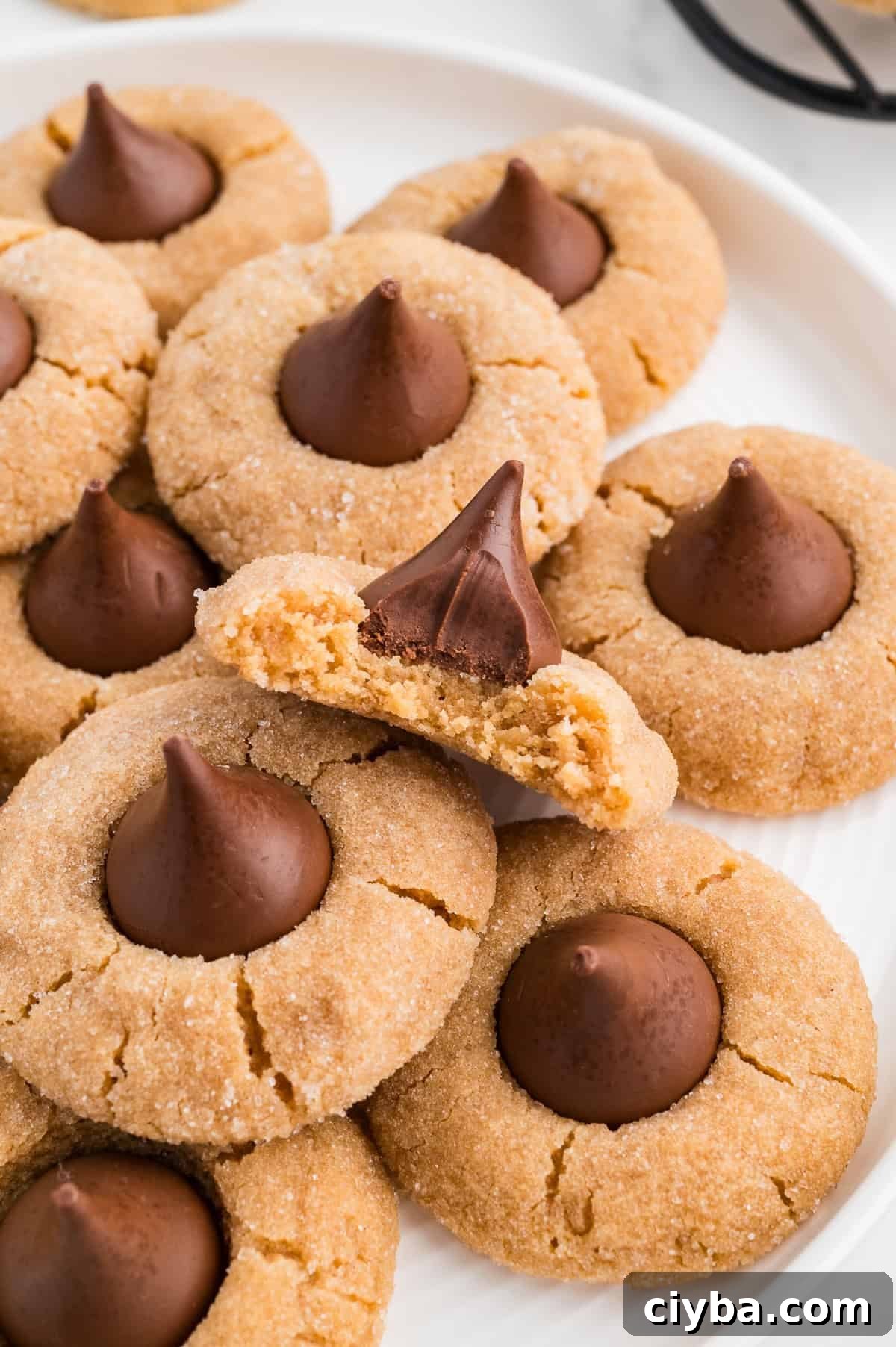 Gluten-Free Peanut Butter Blossoms with Dairy-Free Option 2 Easy Gluten Free Peanut Butter Blossoms (Dairy Free Option Too!) on a plate with a bite taken out