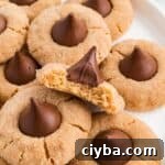 Gluten-Free Peanut Butter Blossoms with Dairy-Free Option 12 Easy Gluten Free Peanut Butter Blossoms (Dairy Free Option Too!) on a plate with a bite taken out