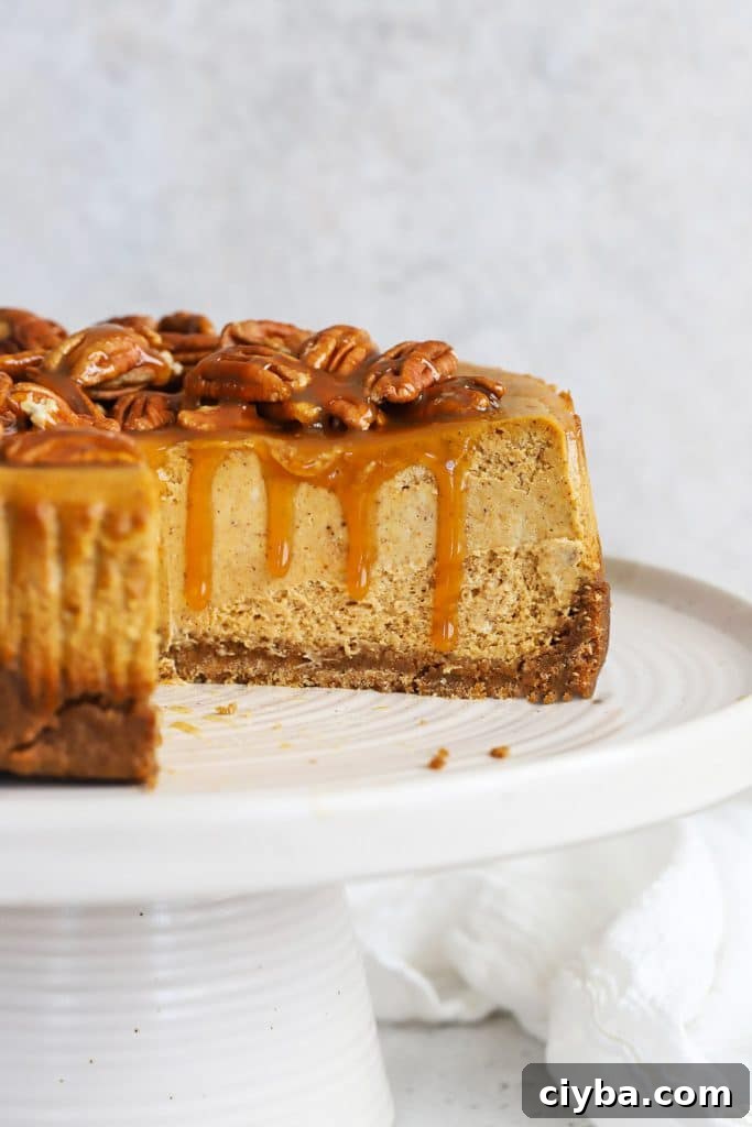 front view of gluten-free pumpkin cheesecake with a few slices out of it