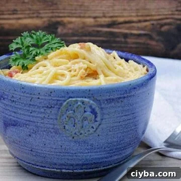 rotel chicken spaghetti in blue bowl with white napkin and fork
