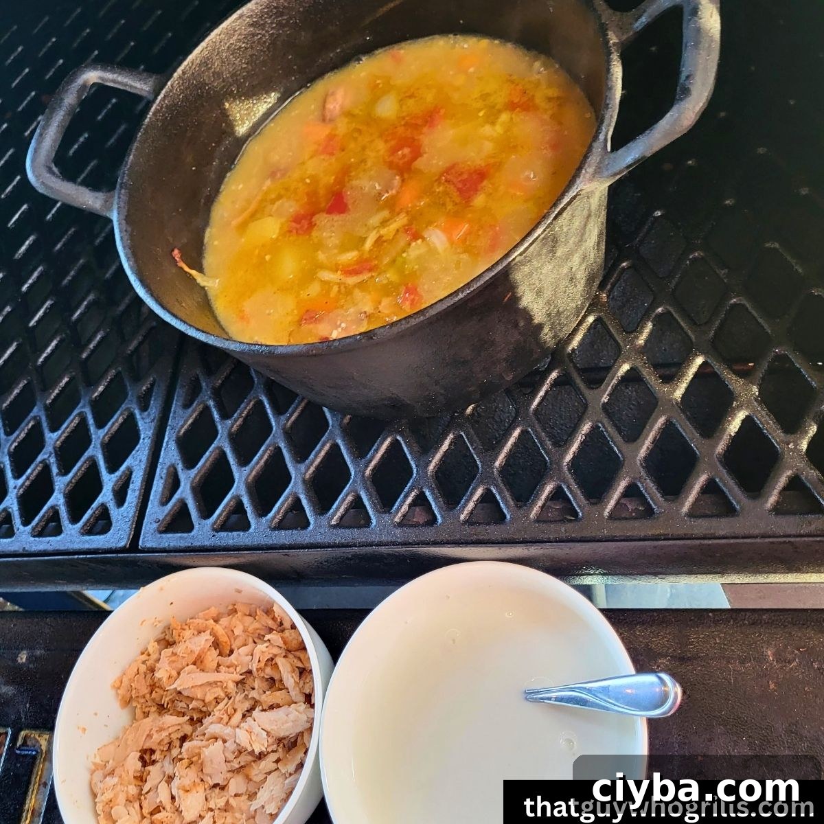 Salmon chowder base in smoker with bowl of shredded Salmon and bowl of heavy whipping cream on grill shelf