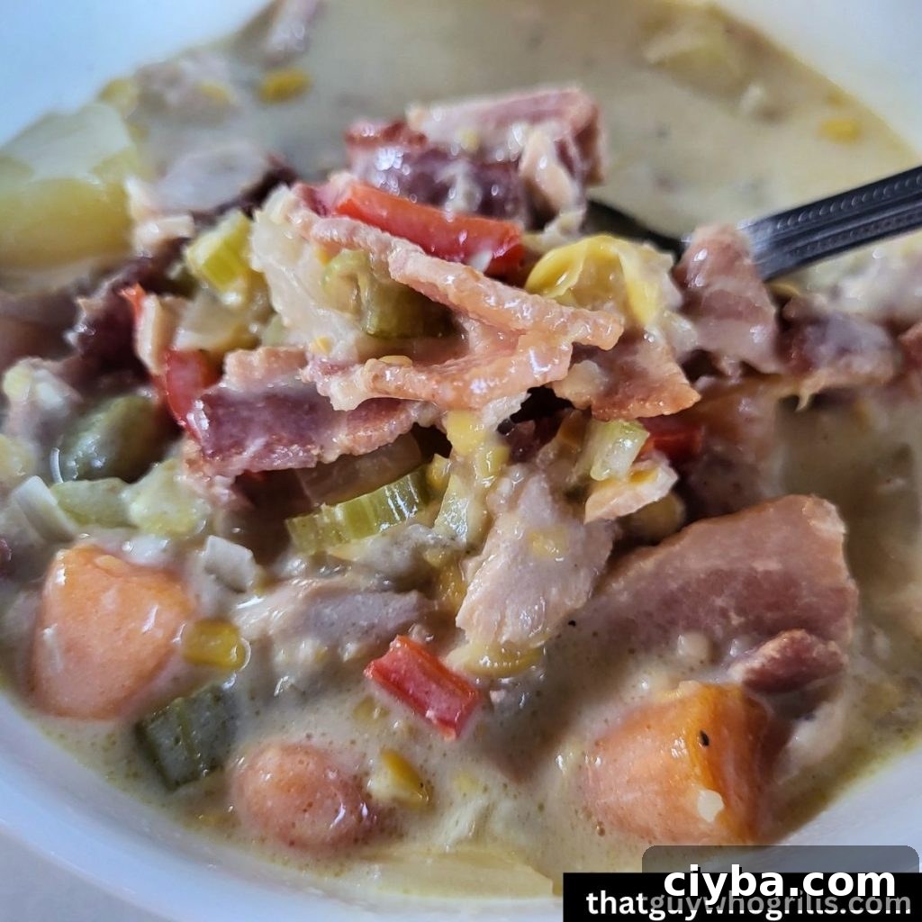 close up of spoonful of smoke salmon chowder over a bowl of chowder