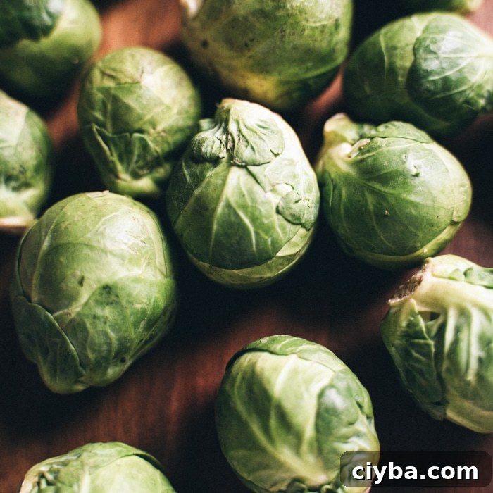 Crispy Air Fryer Brussels Sprouts with Buffalo Ranch Sauce 4 Whole Brussels sprouts on a wooden table.