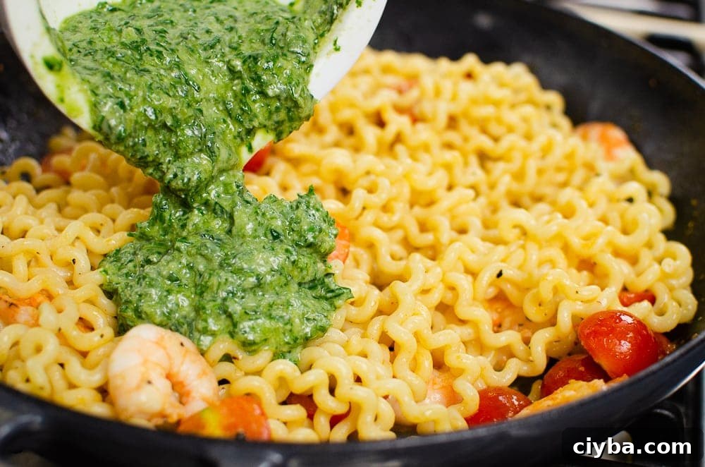 Pesto being added to the cast iron dish to cook our pesto king prawn pasta