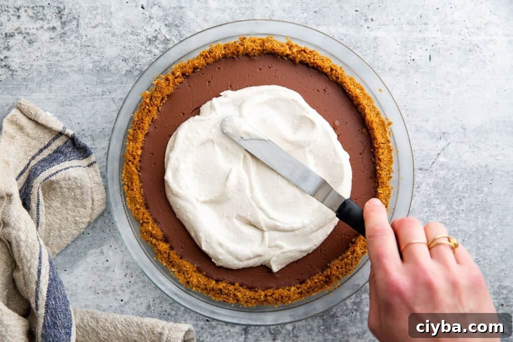 coconut whipped cream spreading on top of a pie