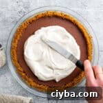 coconut whipped cream spreading on top of a pie