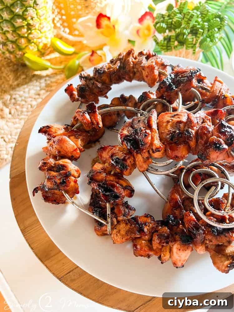 Plate with huli huli chicken kebabs on circular skewers for a tropical cocktail party.