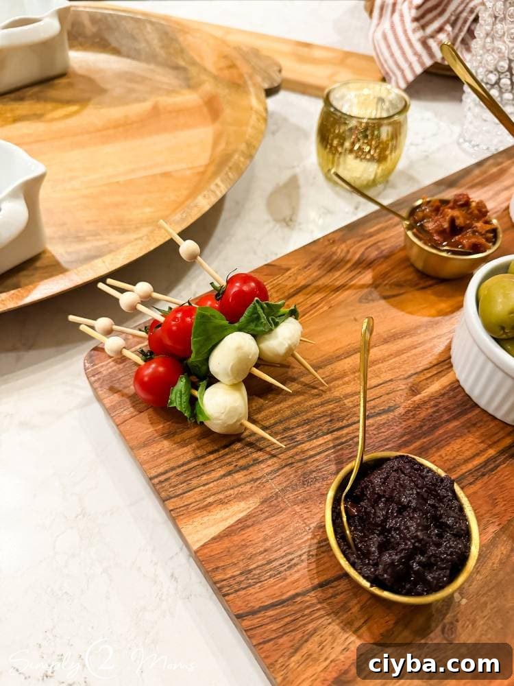 caprese appetizer on bamboo skewer on charcuterie board