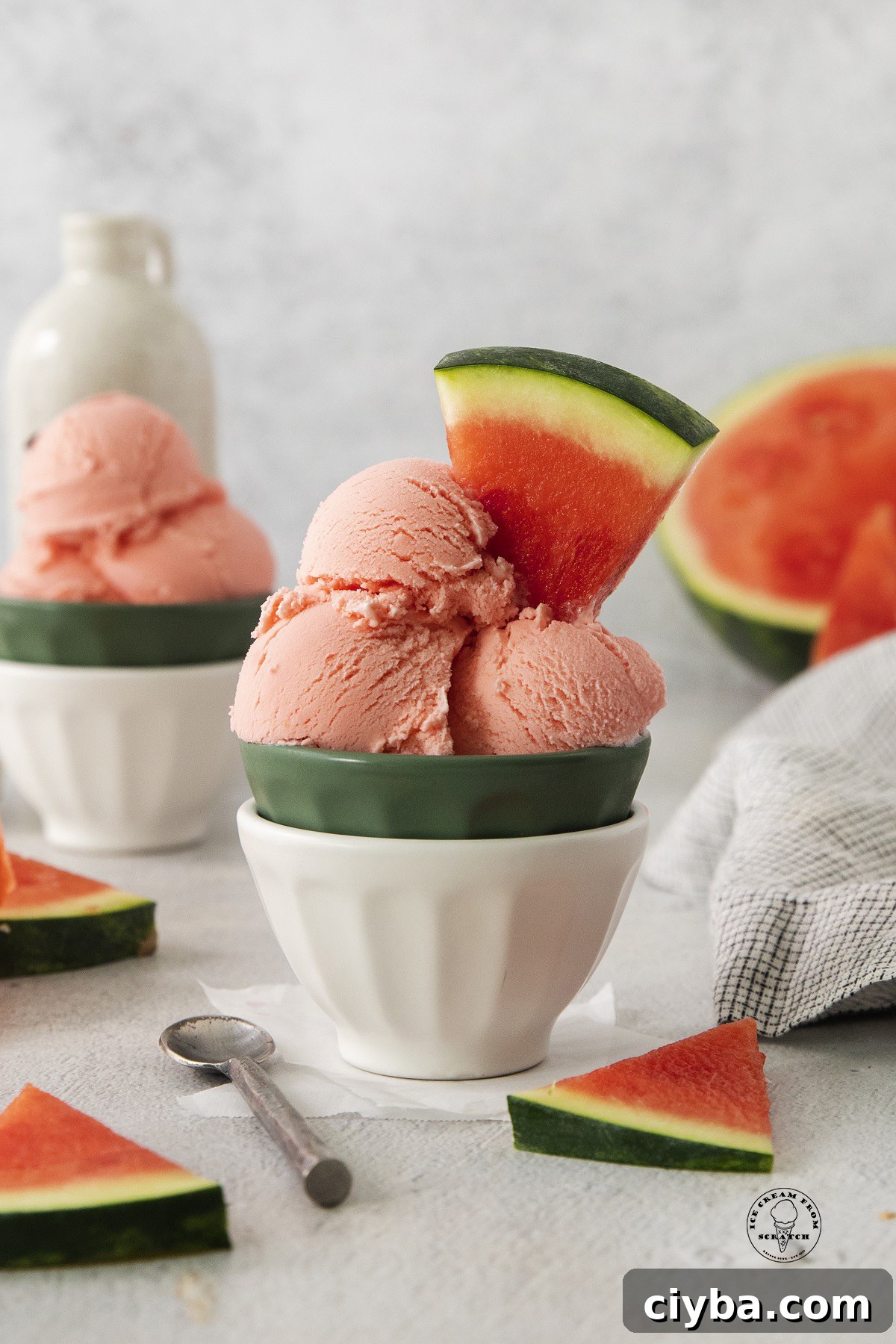 a ceramic bowl filled with scoops of homemade watermelon ice cream. Wedges of fresh watermelon are used as a garnish.