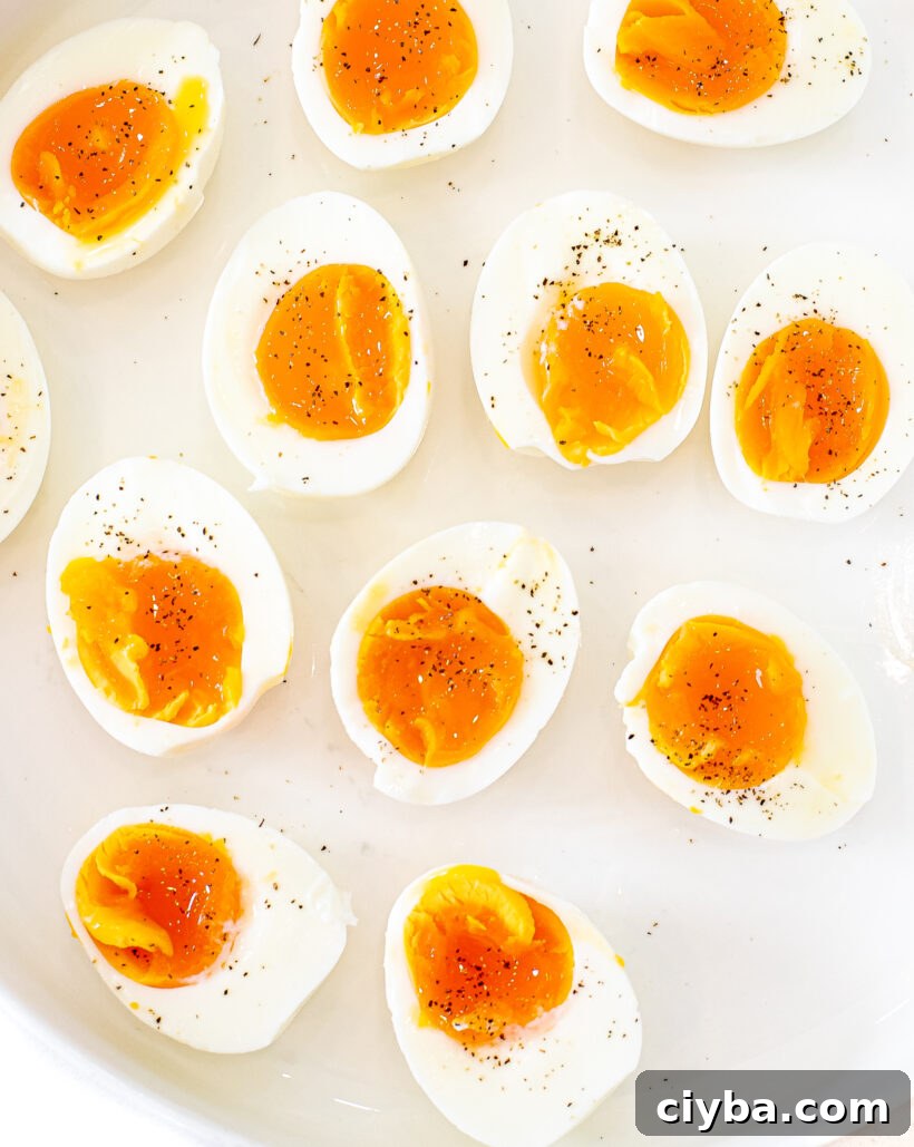 Master Jammy Eggs: Soft-Boiled Eggs with Creamy Yolks 2 Overhead shot of jammy eggs served on a plate sprinkled with pepper.