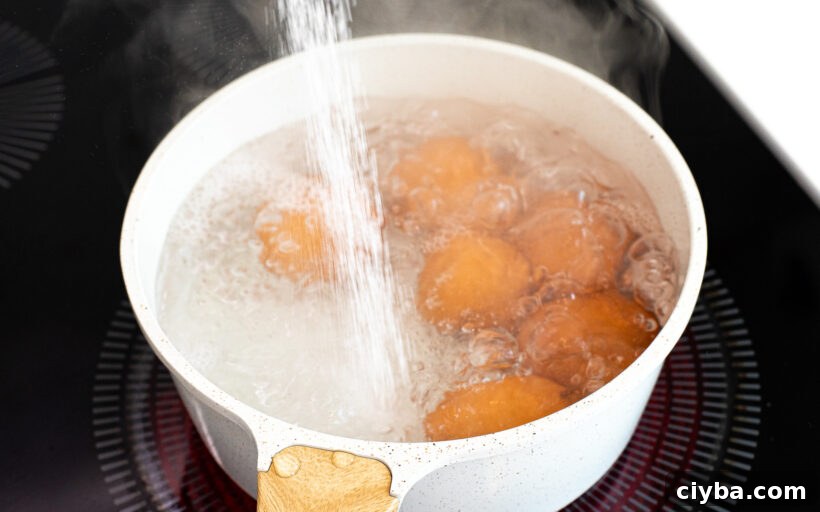Master Jammy Eggs: Soft-Boiled Eggs with Creamy Yolks 4 Salt being poured into a pot of boiling eggs.