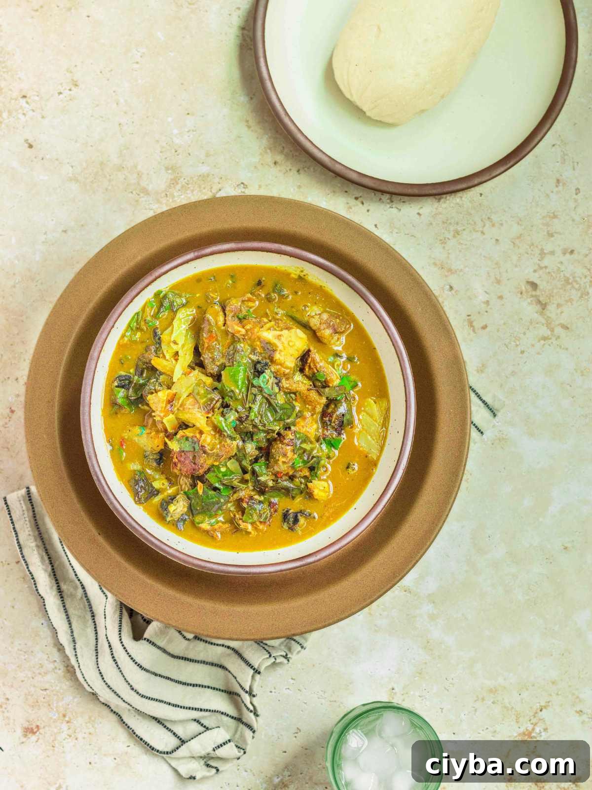 Oha soup in a bowl served with fufu and chilled water.