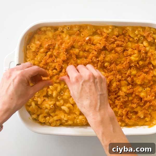 Sprinkling crumble on mac and cheese.