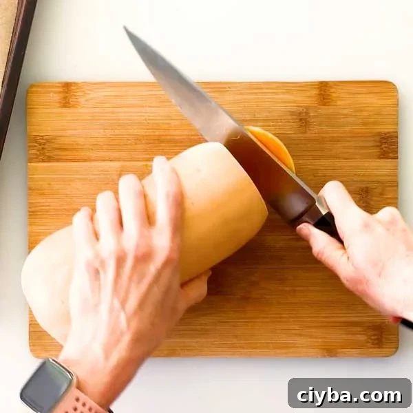 Slicing the end off a butternut squash with a knife.