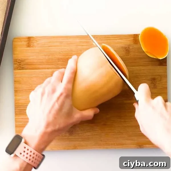 Slicing the bottom of a butternut squash with a knife.