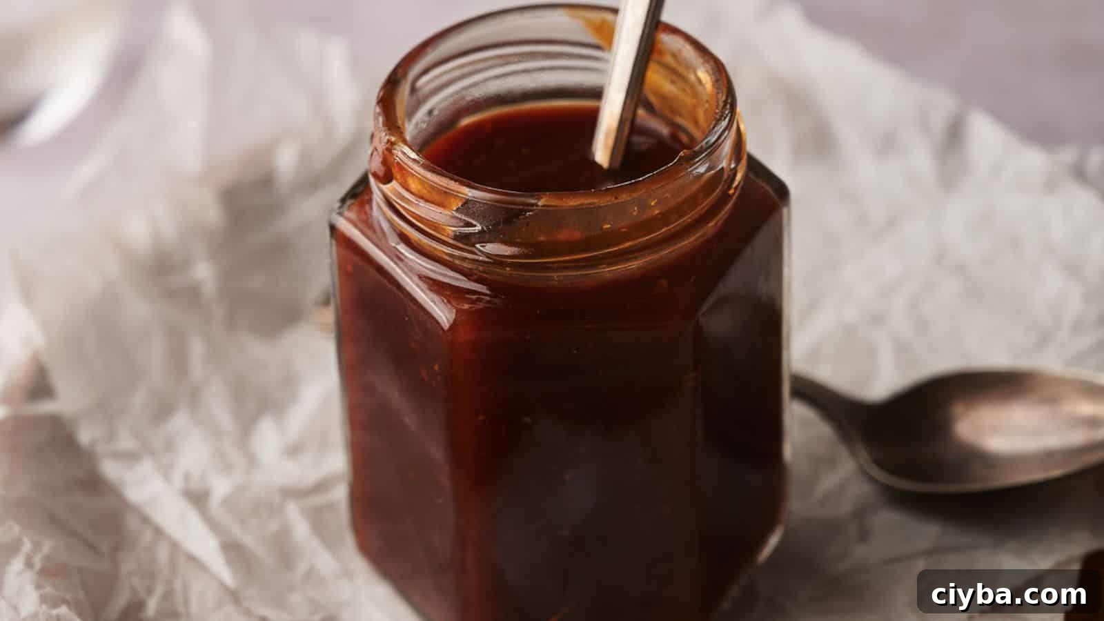 Despite a Busy Schedule, I Completed 17 Dips 12 Homemade BBQ sauce in a jar with two spoons by the side.