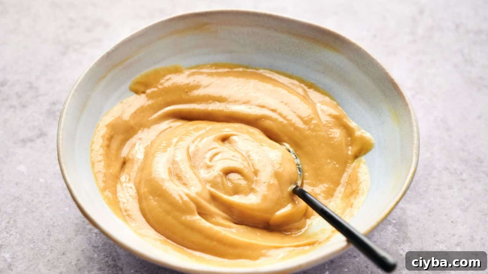 Despite a Busy Schedule, I Completed 17 Dips 17 A bowl of smooth, creamy peanut butter with a hint of Chick-fil-A sauce and a spoon inside.