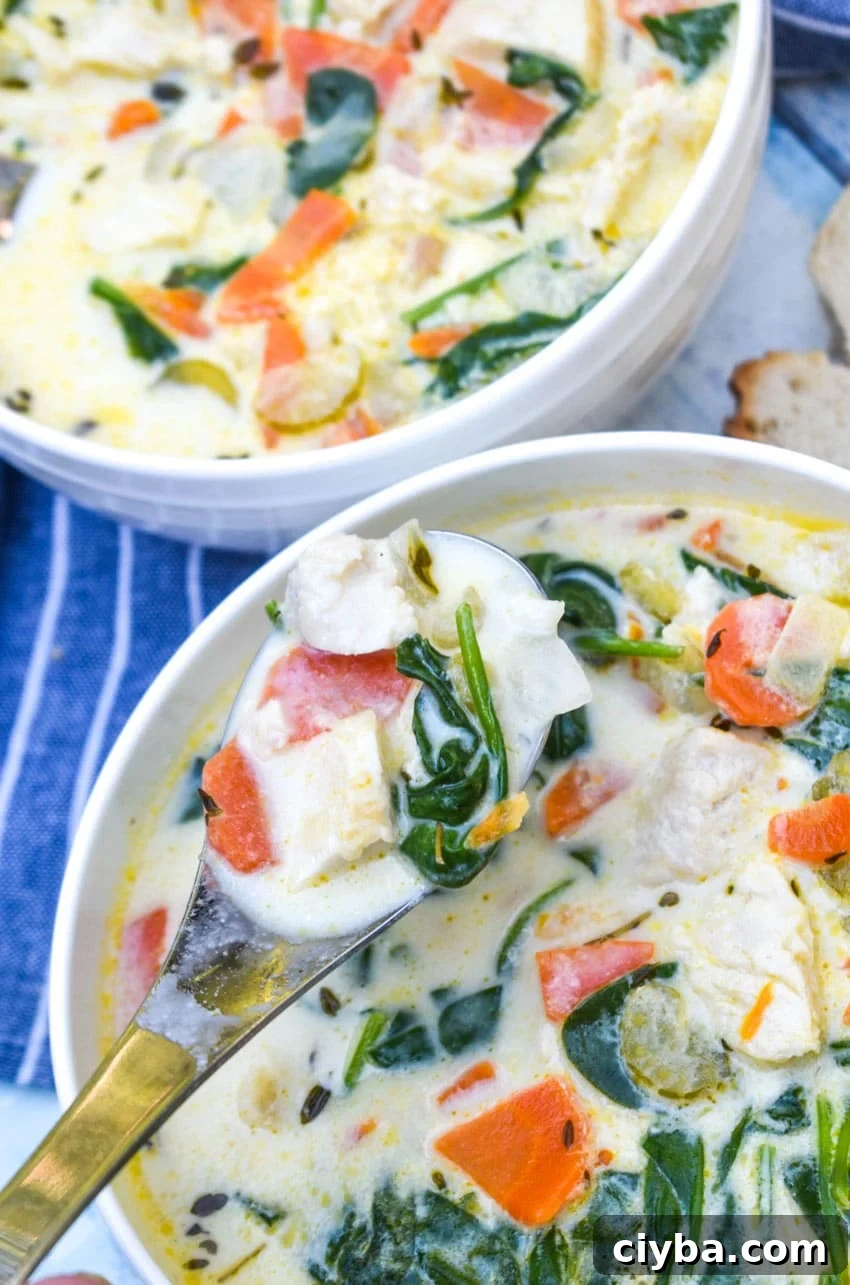 Creamy Chicken Florentine Soup with Spinach and Parmesan 8 a silver spoon holding up a scoop of chicken florentine soup