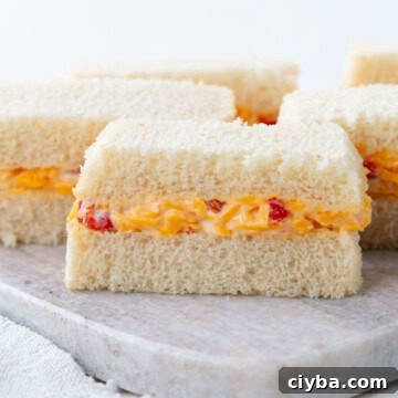 pimento cheese in between two slices of white sandwich bread, cut into thin slices.